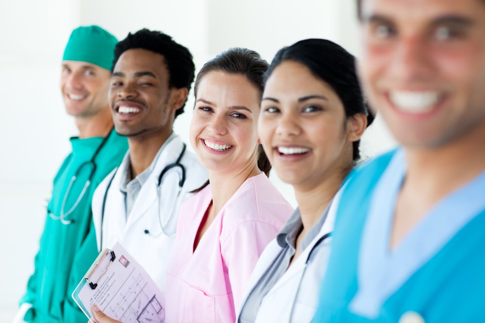 Smiling medical team in a line isolated on a white background